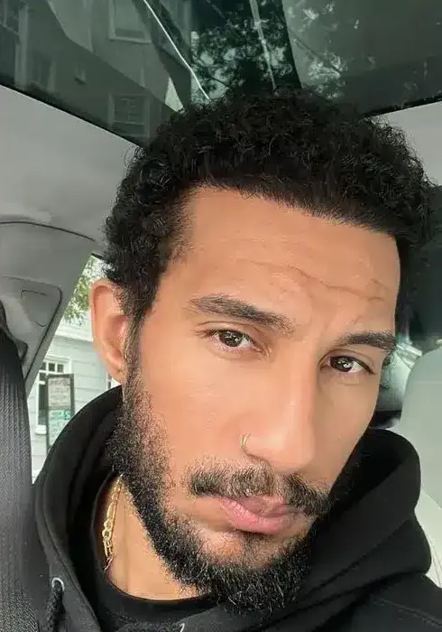 Man with curly Afro-textured hair and a full beard