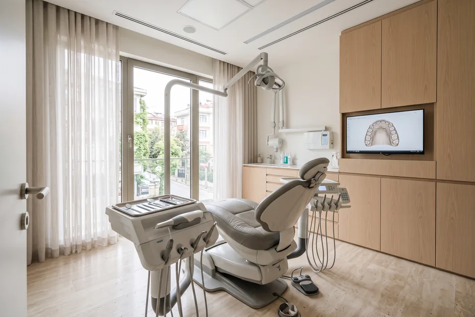 Modern dental treatment room with chair, operatory light and chairside monitor