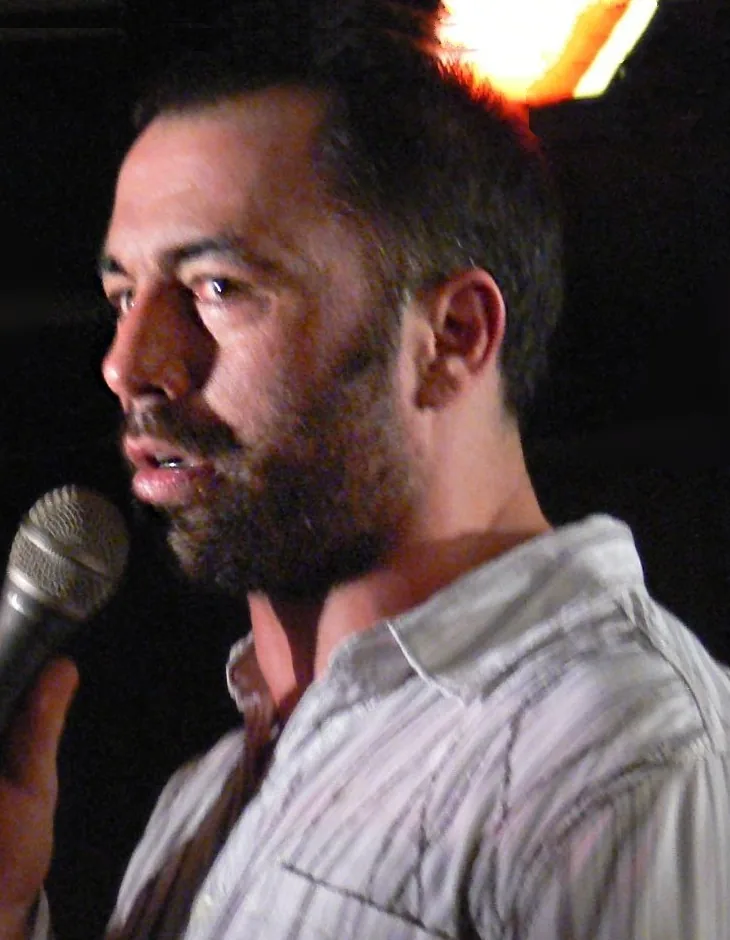 Joe Rogan on stage in 2007 with short hair and a receded temple