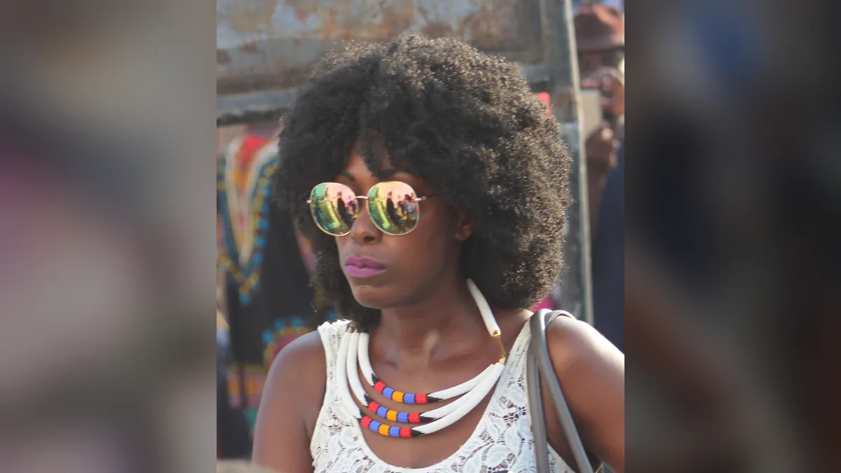 Woman in sunglasses with a full, natural type 4 Afro of tight coils