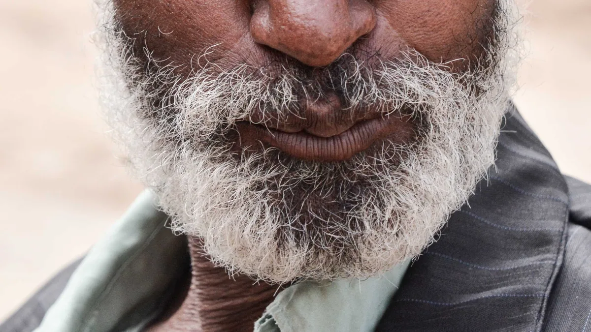 Gros plan d'une barbe grise naturelle aux boucles très serrées